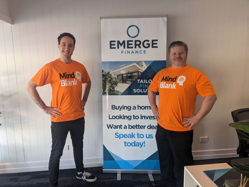 Members of the Mind Blank team pose with an Emerge Finance banner after running a successful workplace mental health training.